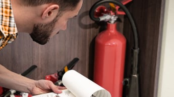 a man examining a fire extinguisher