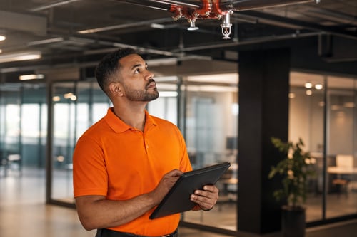 Man Inspecting Fire Sprinklers in Office