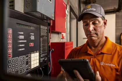 Technician Examining Fire Panel