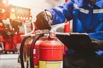 Fire protection technician performing a fire extinguisher inspection in a commercial building